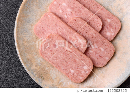 Spiced ham slices, canned meat for lunch sandwiches. Spiced ham as a food background Spiced ham slices, canned meat for lunch sandwiches. Spiced ham as a food background 133502835