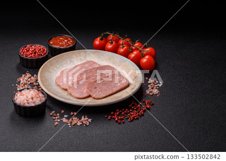 Spiced ham slices, canned meat for lunch sandwiches. Spiced ham as a food background 133502842