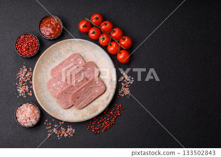 Spiced ham slices, canned meat for lunch sandwiches. Spiced ham as a food background 133502843