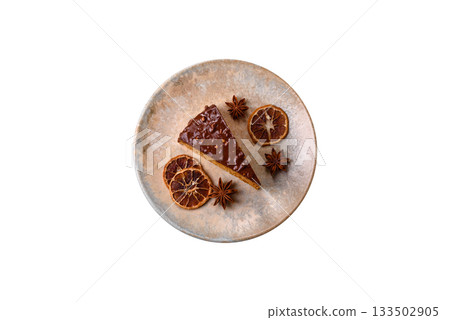 A slice of sweet layered cake covered in chocolate with nuts and caramel. A slice of chocolate cake 133502905