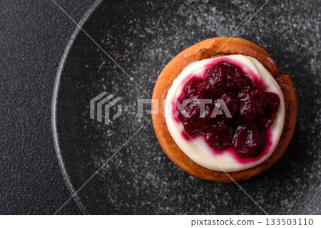 Cinnamon roll, a sweet bun with citrus, cherries, and chocolate, a Danish dessert with cream 133503110
