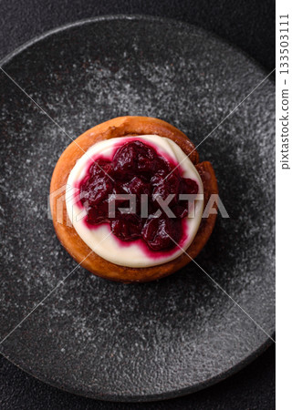 Cinnamon roll, a sweet bun with citrus, cherries, and chocolate, a Danish dessert with cream 133503111