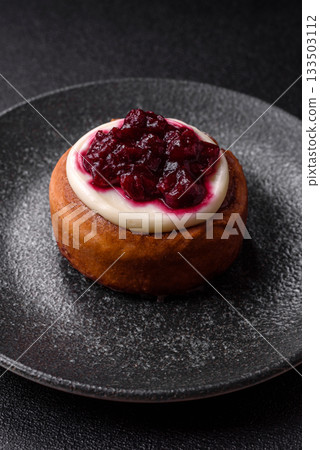 Cinnamon roll, a sweet bun with citrus, cherries, and chocolate, a Danish dessert with cream 133503112