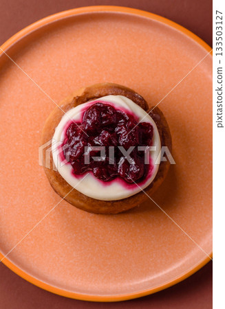 Cinnamon roll, a sweet bun with citrus, cherries, and chocolate, a Danish dessert with cream 133503127