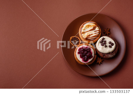 Cinnamon roll, a sweet bun with citrus, cherries, and chocolate, a Danish dessert with cream 133503137