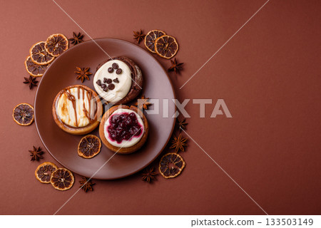 Cinnamon roll, a sweet bun with citrus, cherries, and chocolate, a Danish dessert with cream Cinnamon roll, a sweet bun with citrus, cherries, and chocolate, a Danish dessert with cream 133503149