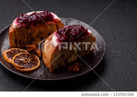 Cinnamon roll, a sweet bun with citrus, cherries, and chocolate, a Danish dessert with cream Cinnamon roll, a sweet bun with citrus, cherries, and chocolate, a Danish dessert with cream 133503160