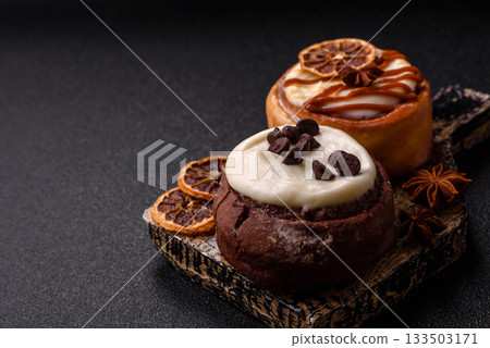 Cinnamon roll, a sweet bun with citrus, cherries, and chocolate, a Danish dessert with cream Cinnamon roll, a sweet bun with citrus, cherries, and chocolate, a Danish dessert with cream 133503171