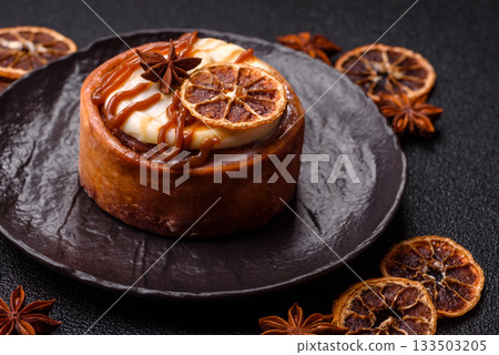 Cinnamon roll, a sweet bun with citrus, cherries, and chocolate, a Danish dessert with cream Cinnamon roll, a sweet bun with citrus, cherries, and chocolate, a Danish dessert with cream 133503205