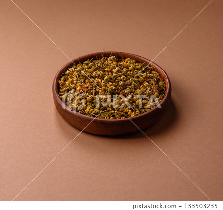 Dried chamomile flowers, herbal tea in a bowl for a hot morning drink. Dried chamomile 133503235