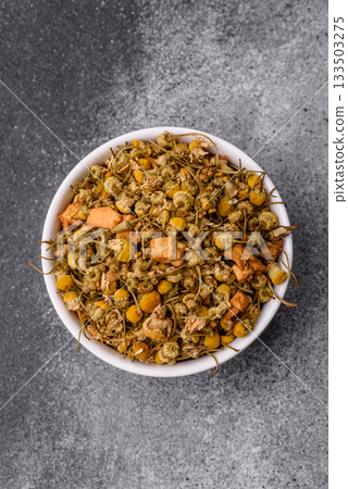 Dried chamomile flowers, herbal tea in a bowl for a hot morning drink. Dried chamomile 133503275