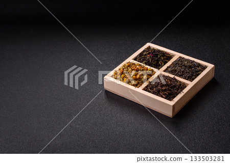 A wooden box with several types of dried tea, green, black, fruit, and chamomile. Dry tea in the box A wooden box with several types of dried tea, green, black, fruit, and chamomile. Dry tea in the box 133503281