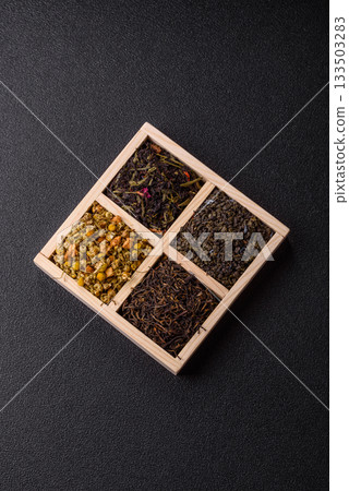 A wooden box with several types of dried tea, green, black, fruit, and chamomile. Dry tea in the box A wooden box with several types of dried tea, green, black, fruit, and chamomile. Dry tea in the box 133503283