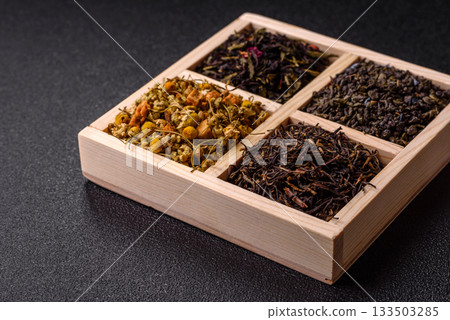 A wooden box with several types of dried tea, green, black, fruit, and chamomile. Dry tea in the box A wooden box with several types of dried tea, green, black, fruit, and chamomile. Dry tea in the box 133503285