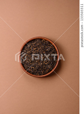 Golden black tea, dried leaves of a Chinese or Indian breakfast drink. Black tea dried leaves Golden black tea, dried leaves of a Chinese or Indian breakfast drink. Black tea dried leaves 133503311