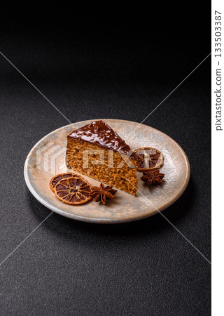 A slice of sweet layered cake covered in chocolate with nuts and caramel. A slice of chocolate cake A slice of sweet layered cake covered in chocolate with nuts and caramel. A slice of chocolate cake 133503387