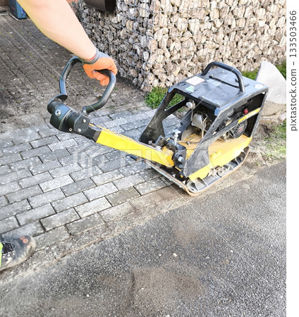 Laying paving slabs using a vibrating plate 133503466