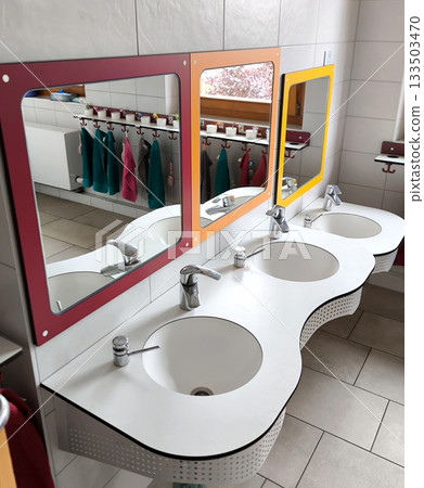 A bathroom in a kindergarten. Colored mirrors with sinks for children. 133503470