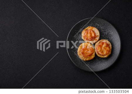 Round fish or chicken cutlets baked with tomato and cheese. Fish cutlets 133503504