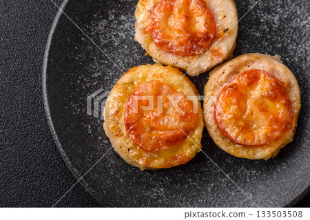 Round fish or chicken cutlets baked with tomato and cheese. Fish cutlets Round fish or chicken cutlets baked with tomato and cheese. Fish cutlets 133503508