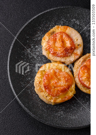 Round fish or chicken cutlets baked with tomato and cheese. Fish cutlets Round fish or chicken cutlets baked with tomato and cheese. Fish cutlets 133503509