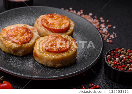 Round fish or chicken cutlets baked with tomato and cheese. Fish cutlets 133503511
