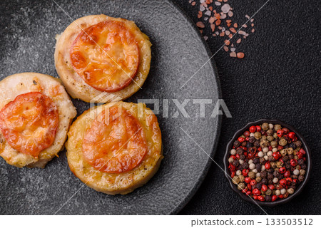 Round fish or chicken cutlets baked with tomato and cheese. Fish cutlets Round fish or chicken cutlets baked with tomato and cheese. Fish cutlets 133503512