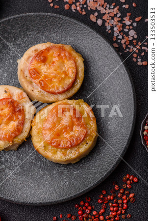 Round fish or chicken cutlets baked with tomato and cheese. Fish cutlets 133503513