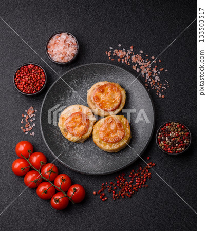 Round fish or chicken cutlets baked with tomato and cheese. Fish cutlets 133503517