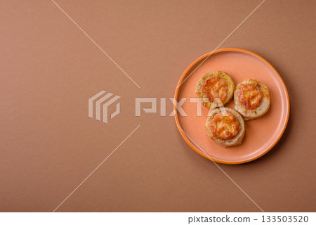 Round fish or chicken cutlets baked with tomato and cheese. Fish cutlets Round fish or chicken cutlets baked with tomato and cheese. Fish cutlets 133503520