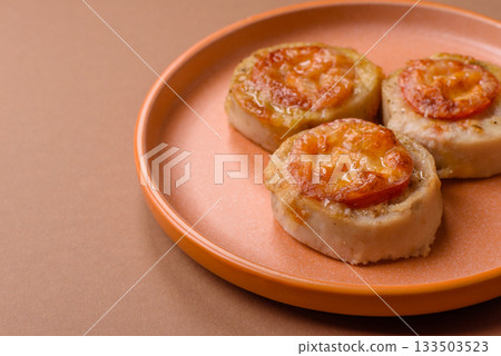 Round fish or chicken cutlets baked with tomato and cheese. Fish cutlets Round fish or chicken cutlets baked with tomato and cheese. Fish cutlets 133503523