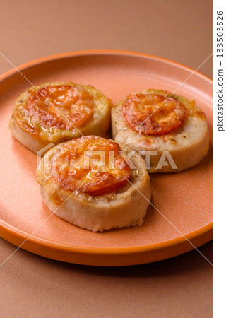 Round fish or chicken cutlets baked with tomato and cheese. Fish cutlets 133503526