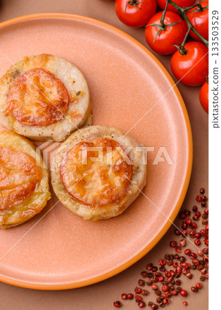 Round fish or chicken cutlets baked with tomato and cheese. Fish cutlets 133503529