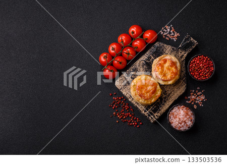 Round fish or chicken cutlets baked with tomato and cheese. Fish cutlets 133503536