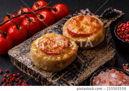 Round fish or chicken cutlets baked with tomato and cheese. Fish cutlets 133503539
