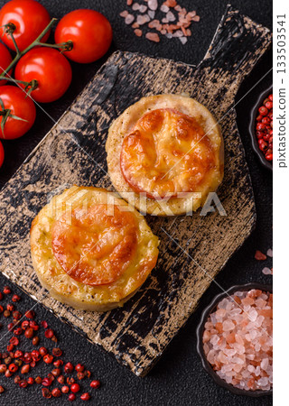 Round fish or chicken cutlets baked with tomato and cheese. Fish cutlets 133503541
