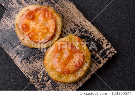 Round fish or chicken cutlets baked with tomato and cheese. Fish cutlets 133503544