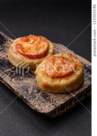 Round fish or chicken cutlets baked with tomato and cheese. Fish cutlets Round fish or chicken cutlets baked with tomato and cheese. Fish cutlets 133503546