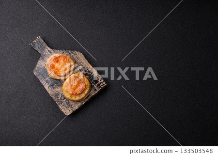 Round fish or chicken cutlets baked with tomato and cheese. Fish cutlets Round fish or chicken cutlets baked with tomato and cheese. Fish cutlets 133503548