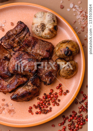 Beef, grilled meat in pieces, or kebab with sauce and vegetables. Beef in pieces 133503664