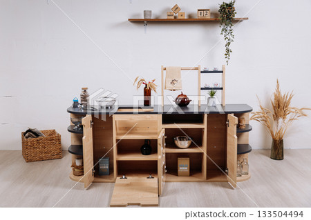 Wooden kids play kitchen with shelves and accessories in minimalist nursery interior Wooden kids play kitchen with shelves and accessories in minimalist nursery interior 133504494