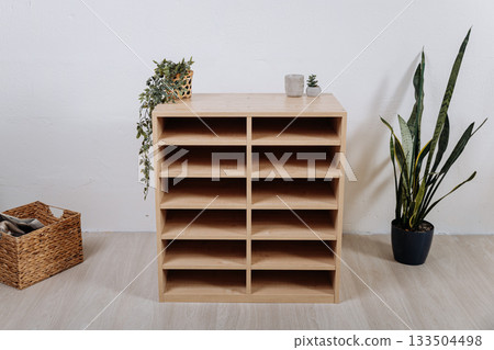 Wooden multi tier shelf cabinet in modern playroom interior, front view 133504498