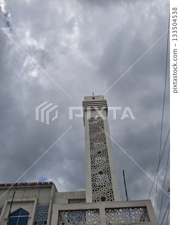 Elegant Mosque Exterior Under a Cloudy Sky with Intricate Architectural Details Elegant Mosque Exterior Under a Cloudy Sky with Intricate Architectural Details 133504538