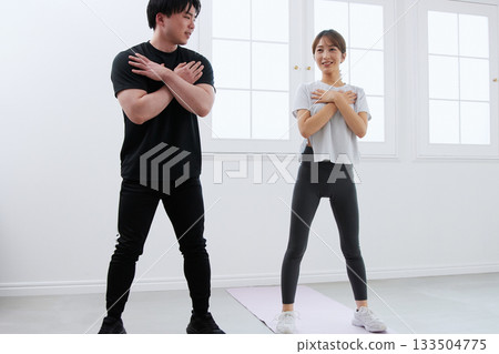 Young woman receiving training from a personal trainer Young woman receiving training from a personal trainer 133504775