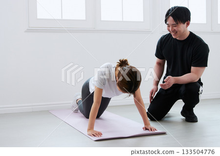 Young woman receiving training from a personal trainer Young woman receiving training from a personal trainer 133504776