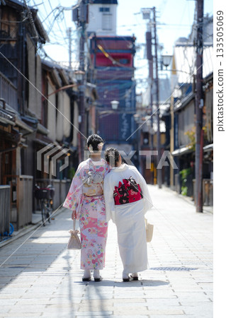 Back view of two women in kimono walking through a traditional street in Kyoto, Japan Back view of two women in kimono walking through a traditional street in Kyoto, Japan 133505069
