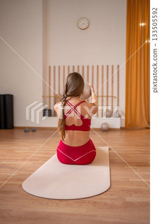 Woman doing core exercises with stability balls under in modern pilates studio 133505592