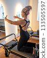 Woman with dreadlocks determined woman in black leggings performs pilates with focused energy 133505597