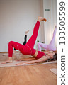 Pilates women performing inverted leg raises, pair of women practicing inverted leg raises with focus on the buttocks 133505599
