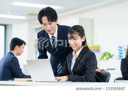 工作在辦公室的一個年輕商人 工作在辦公室的一個年輕商人 133505687